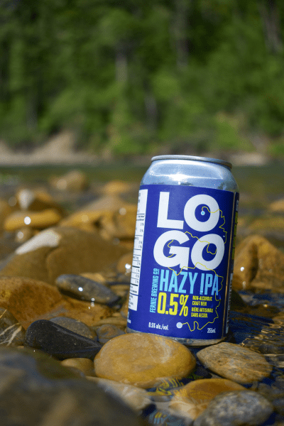 A can of LOGO Hazy IPA at the edge of a river